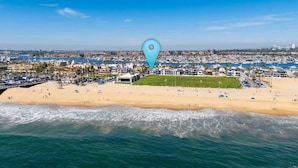 Eine Küstenstadt mit Strand, Gebäuden und blauem Himmel.