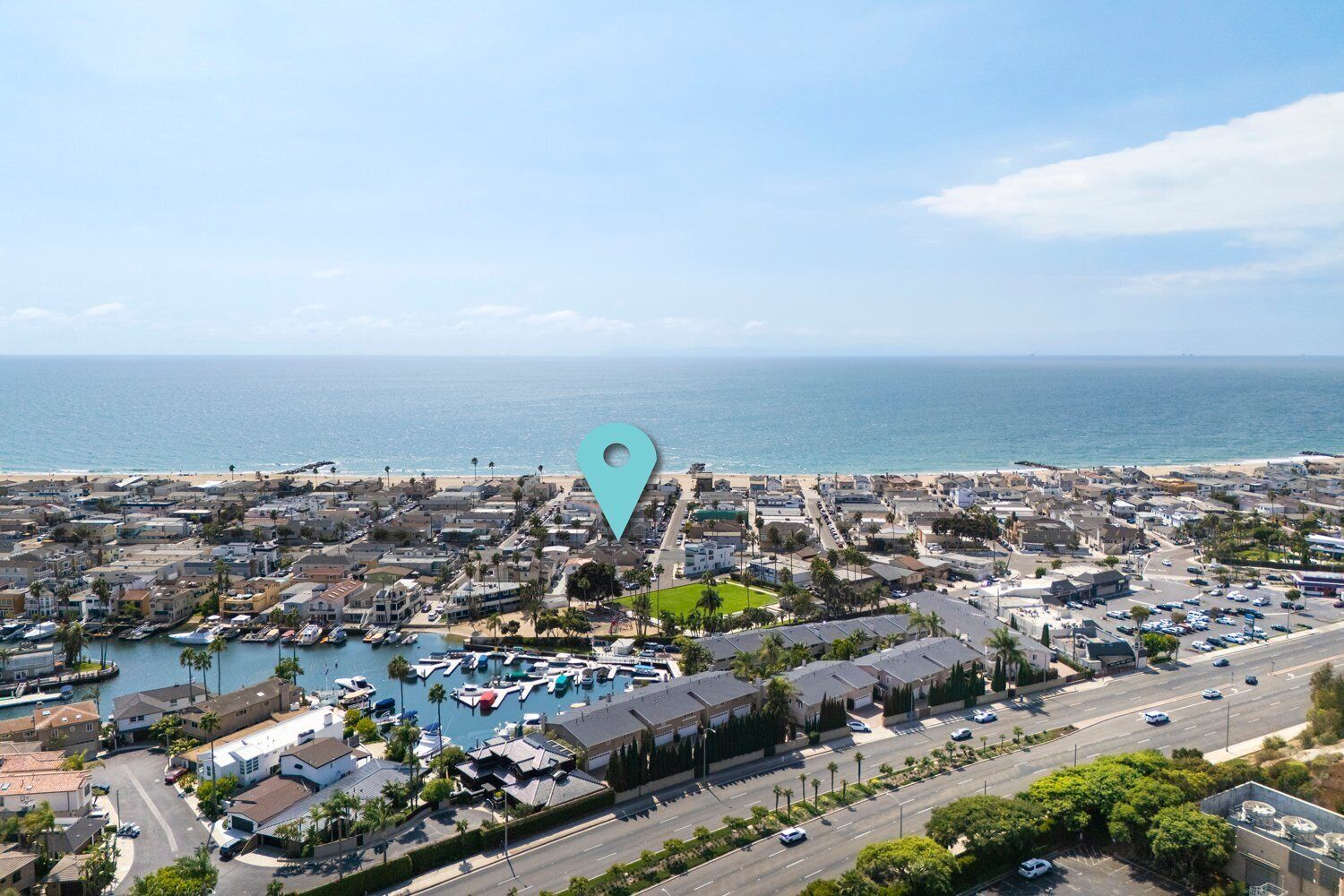 A coastal town with a marina, residential buildings, and a beach.