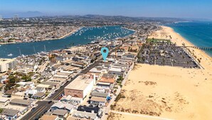 An aerial view of a coastal city with a marina, sandy beaches, and a mix of residential and commercial buildings. - Balboa Hideaway w/ Patio next to Pier, Fun Zone, (Newport Beach)