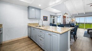 A spacious kitchen with a large island, wooden flooring, and a view of the outdoors. - 2 Beachfront Condos with Private Balcony (Newport Beach)