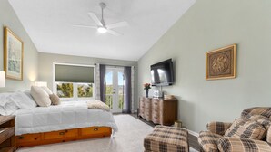 Une chambre à coucher avec un lit, une commode, un téléviseur et une chaise.