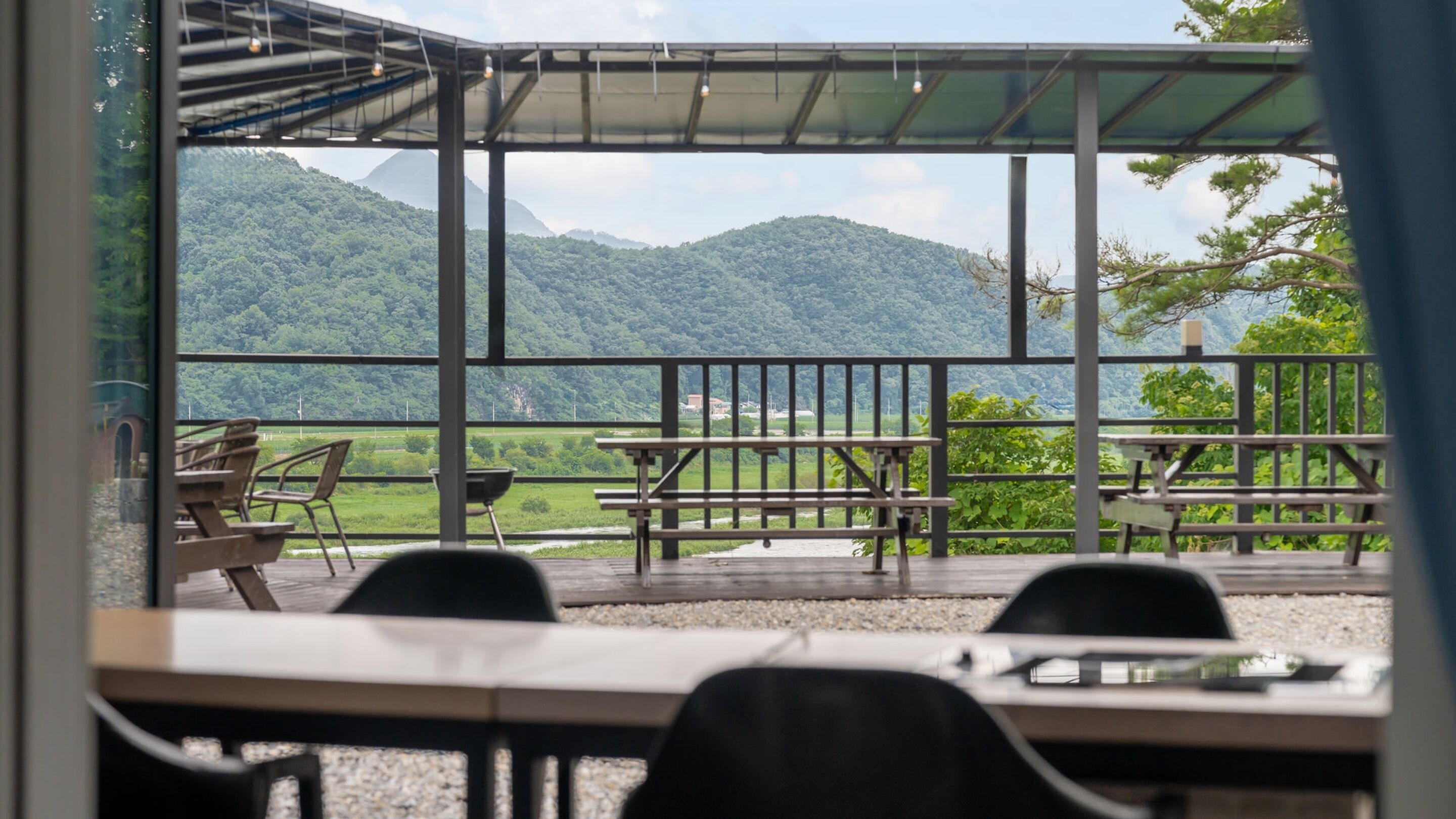 A terrace with tables and chairs, overlooking a mountainous landscape.