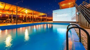 Relax by the pool under the stars, where a covered seating area offers comfortable tables and chairs.