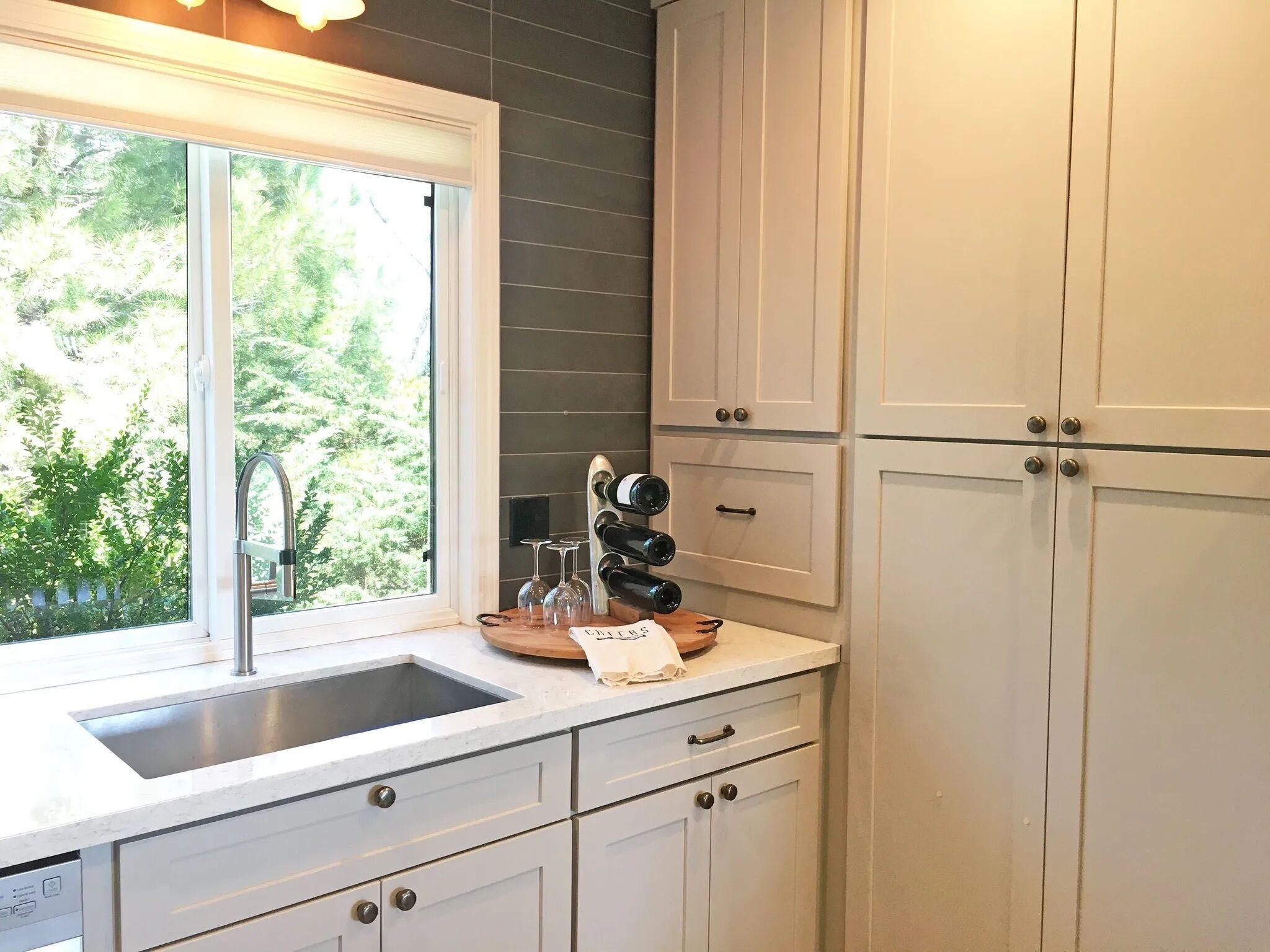 A kitchen with a window, a sink, and cabinets.