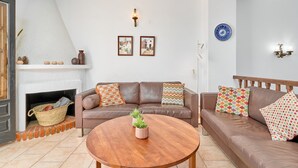 Ein Wohnzimmer mit Kamin, zwei Sofas, einem Couchtisch und Wanddekoration.