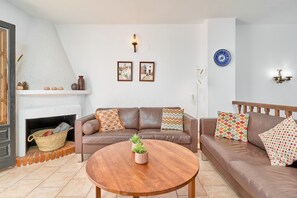 A living room with a fireplace, two sofas, a coffee table, and wall-mounted decor. - Apartment 'Calle Isabel 13' with Sea View, Wi-Fi and Air Conditioning (Nerja)