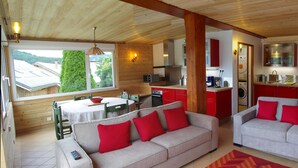 Een gezellige kamer met een bank, een eettafel en een keukenhoek.