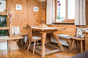 Un interno in legno con un tavolo da pranzo, sedie e una panca.