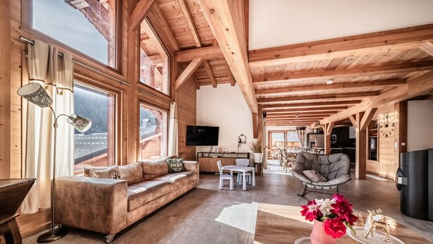 A spacious wooden interior with a sofa, dining table, and a TV. - Chalet 'Heidi - Chatel' with Mountain View, Private Terrace and Wi-Fi (Châtel)