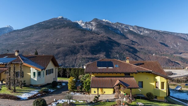 Un quartier résidentiel avec des maisons, un ciel dégagé et une montagne en arrière-plan.