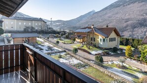 Un quartier résidentiel avec des maisons, une route asphaltée et une montagne en arrière-plan.