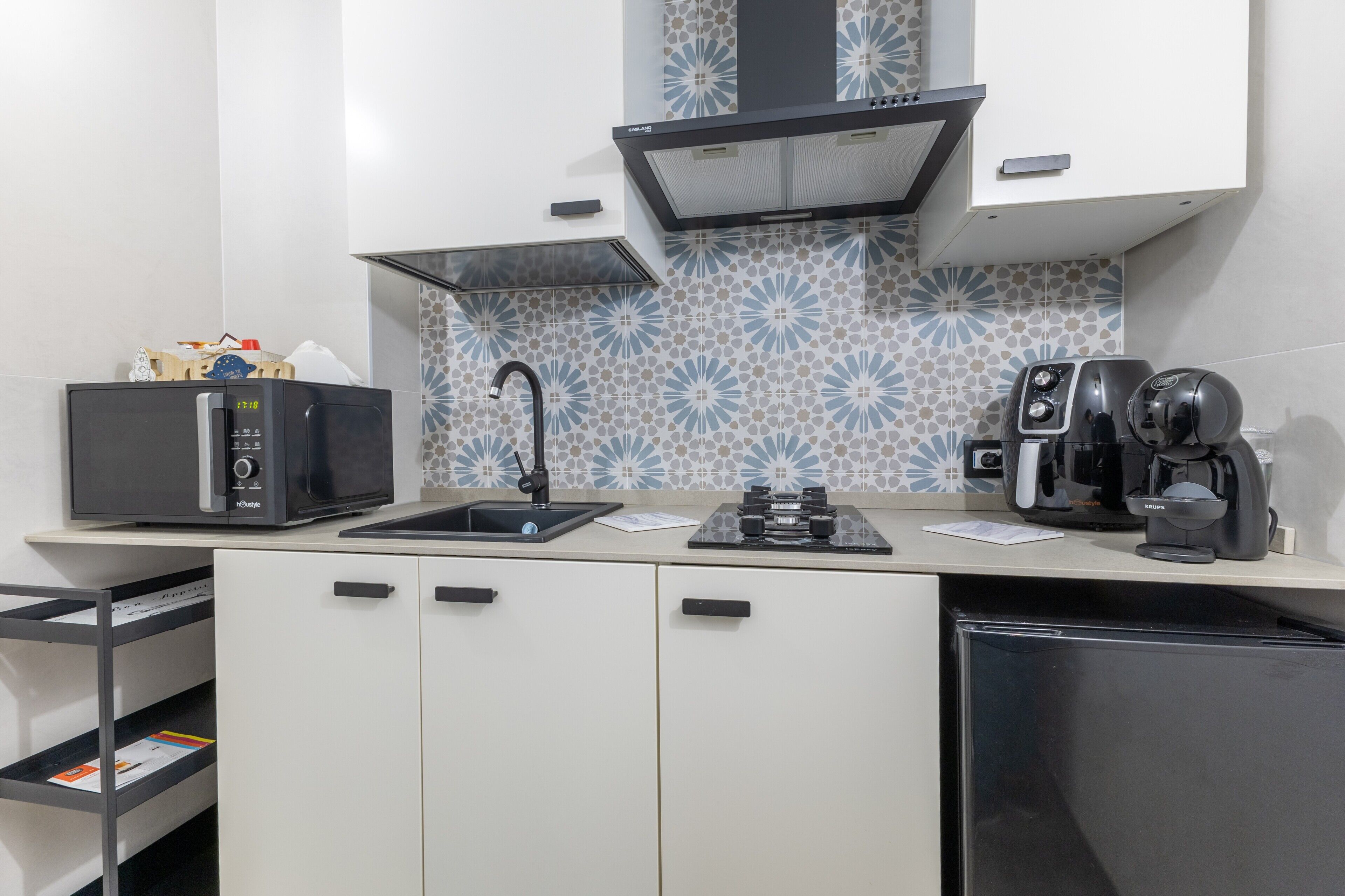 A modern kitchen with a microwave, coffee maker, and a sink.