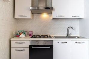 Une cuisine moderne équipée d’une cuisinière en acier inoxydable, d’un lave-vaisselle et d’un évier.