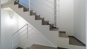 A modern staircase with a glass railing and a light fixture on the wall. - Holiday Home "La Dimora della Luna" with Sea View, Terrace and Wi-Fi (Pozzallo)