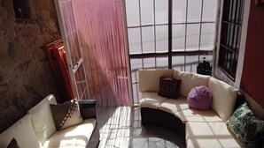 Una stanza accogliente con un divano curvo, un tappeto decorato e un pavimento in pietra.