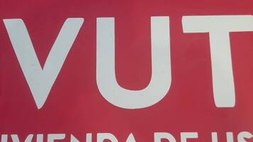 Un panneau rouge avec du texte blanc indiquant : « VUT », « IVIENDA DE US » et « TURÍSTICO ».