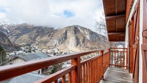 Un balcón de madera con vistas a un pueblo montañoso.
