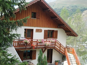 Eine Holzchalet mit Balkon, Holzh shutters und einem Schild, das ein Restaurant anzeigt.
