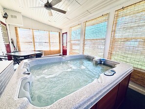 A hot tub with a view of the outdoors, a ceiling fan, and a table with chairs. - Full basement apartment quiet comfy 1-bedroom with shared Hot tub.  (Wilmington)