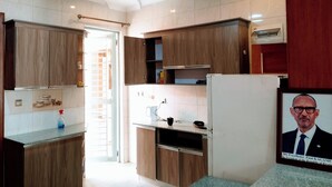 A modern kitchen with wooden cabinets, a built-in oven, and a refrigerator. - KIGALI FANTASTIC HOME AND BOUTIQUE HOTEL (Kigali)