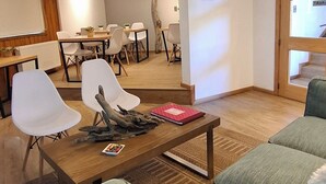 Una sala de estar moderna con sofá, una mesa de centro y un comedor con sillas y una mesa.