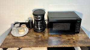 A kitchen counter with a coffee maker, a microwave, and a coffee pot. - Charming Private Studio in the Heart of Jasper (Jasper)