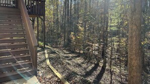 A wooden deck with a staircase leading to a viewing platform, surrounded by a forest with sunlight filtering through the trees. - Charming Private Studio in the Heart of Jasper (Jasper)