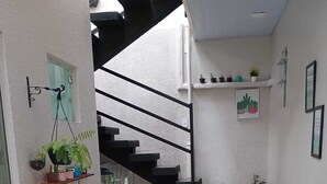 Een trap die leidt naar een plateau met potplanten aan weerszijden.