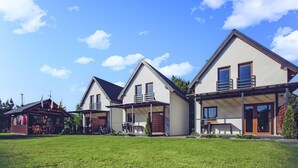 Een rij moderne huizen met een verzorgd gazon en helderblauwe lucht.