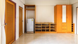 Une pièce équipée d’un réfrigérateur, d’une armoire en bois et d’étagères.