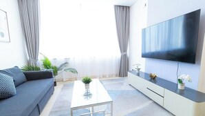 Un salon moderne comprenant un canapé, une table basse, un téléviseur et un meuble.