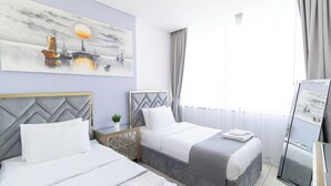 Une chambre d’hôtel avec deux lits, une grande fenêtre et un tableau au mur.
