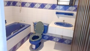 A bathroom with a bathtub, toilet, and sink. - Mitr inn Phuket Old town (Phuket)