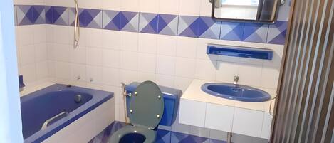 A bathroom with a bathtub, toilet, and sink.
