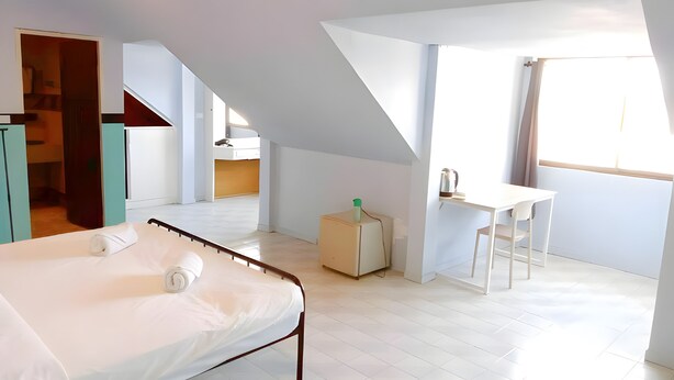 A bedroom with a bed, a desk, and a window. - Mitr inn Phuket Old town (Phuket)