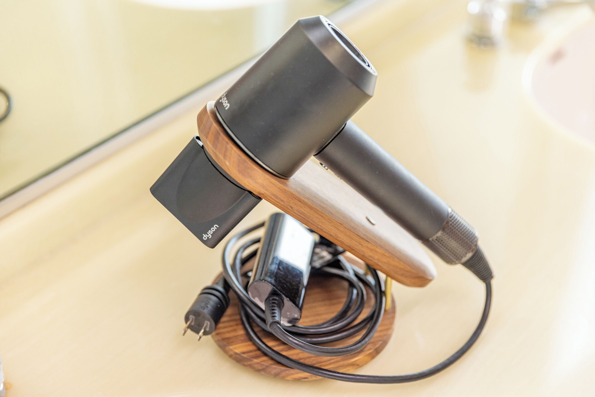 A microphone on a wooden stand with a cable and a power adapter.