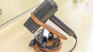 A microphone on a wooden stand with a cable and a power adapter.