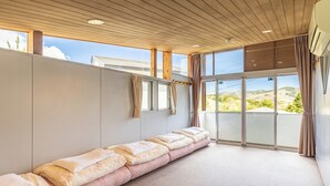 Una habitación con un largo banco, ventanas amplias y vistas al exterior.
