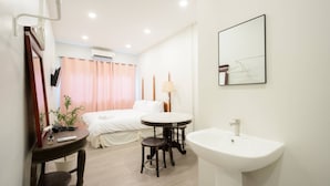 A hotel room with a bed, bedside table, lamp, and a large mirror. - CASA Yaowarat (Bangkok)