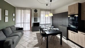 Um apartamento moderno com sala de jantar, cozinha e sala de estar.