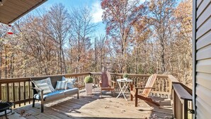 A wooden deck with a sofa, chairs, and a small table.