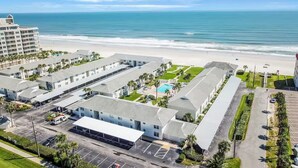 Un hôtel comprenant plusieurs bâtiments, un parking et offrant une vue sur la plage.