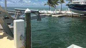 A marina with boats docked, a lifeline sign, and palm trees in the background. - Open Ocean View, Private Hot Tub, Ice Machine, Moor 26' Boat! (Marathon)