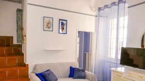 A room with a sofa, a television, and a staircase. - Casa della Mamma by Interhome (Riva Ligure)