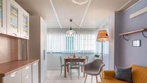 A modern kitchen with a dining area, a sofa, and a floor lamp. - Casa della Mamma by Interhome (Riva Ligure)