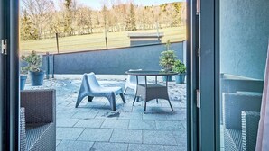 An outdoor patio with wicker furniture and potted plants. - Nice apartment for 4 people with WIFI, TV and terrace (Vrchlabí)
