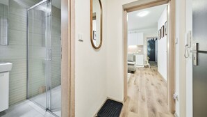 A modern bathroom with a glass shower enclosure, a white sink, and a mirror. - Nice apartment for 4 people with WIFI, TV and terrace (Vrchlabí)