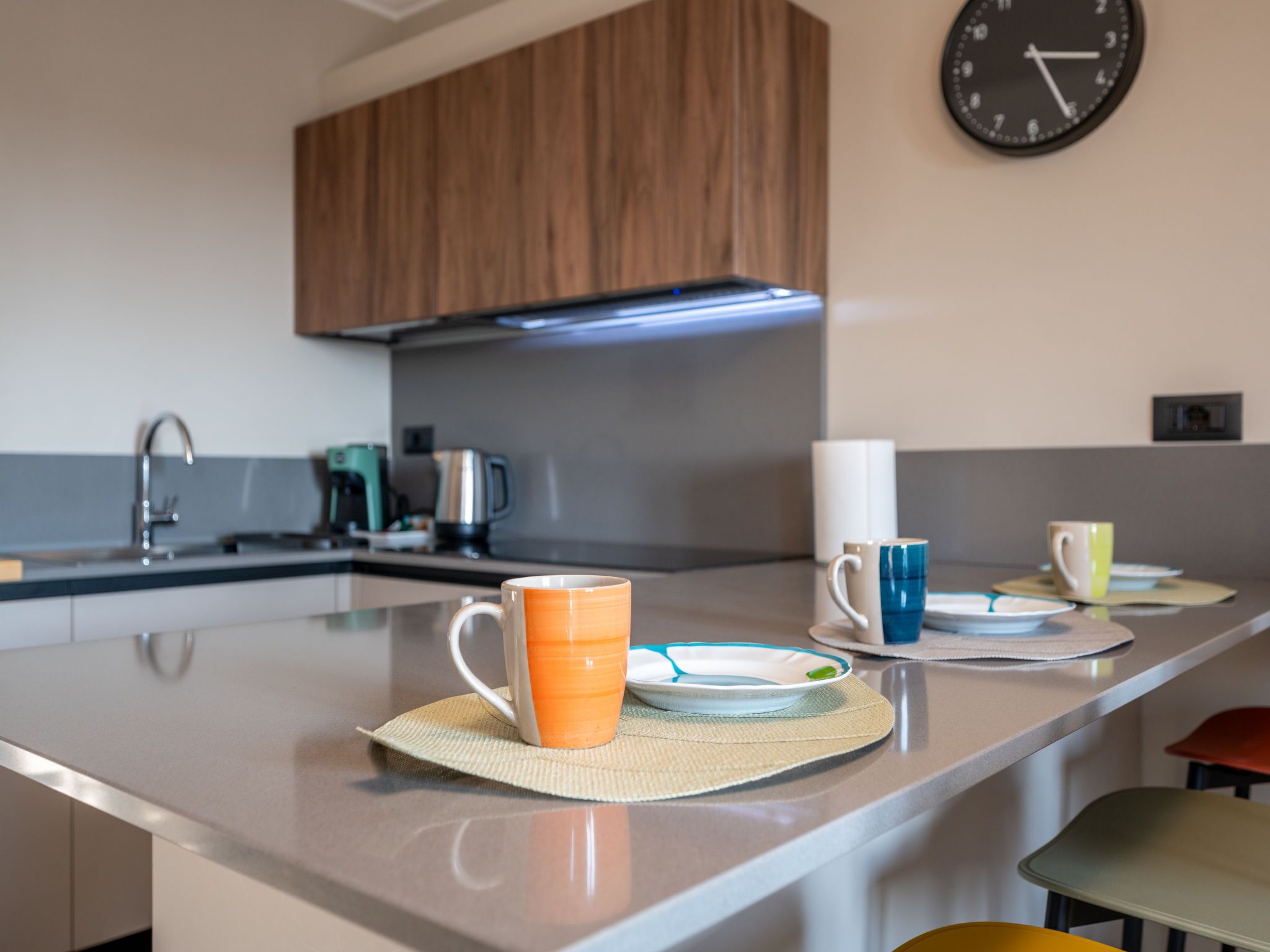 A modern kitchen with a central island, stainless steel appliances, and wooden cabinets.