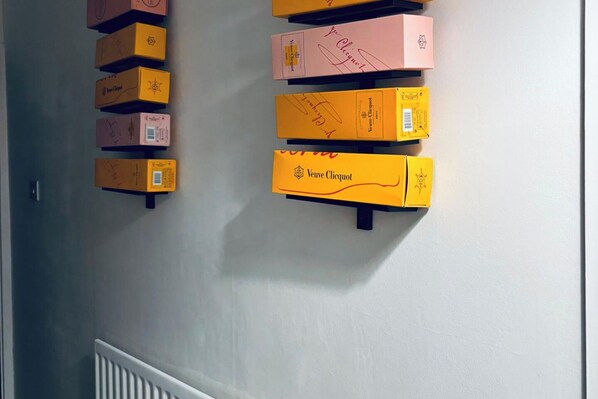 A wall with multiple boxes of Veuve Clicquot champagne bottles.