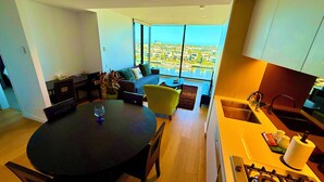 Een moderne keuken met een gasfornuis, een spoelbak en een eethoek met een ronde tafel en stoelen.